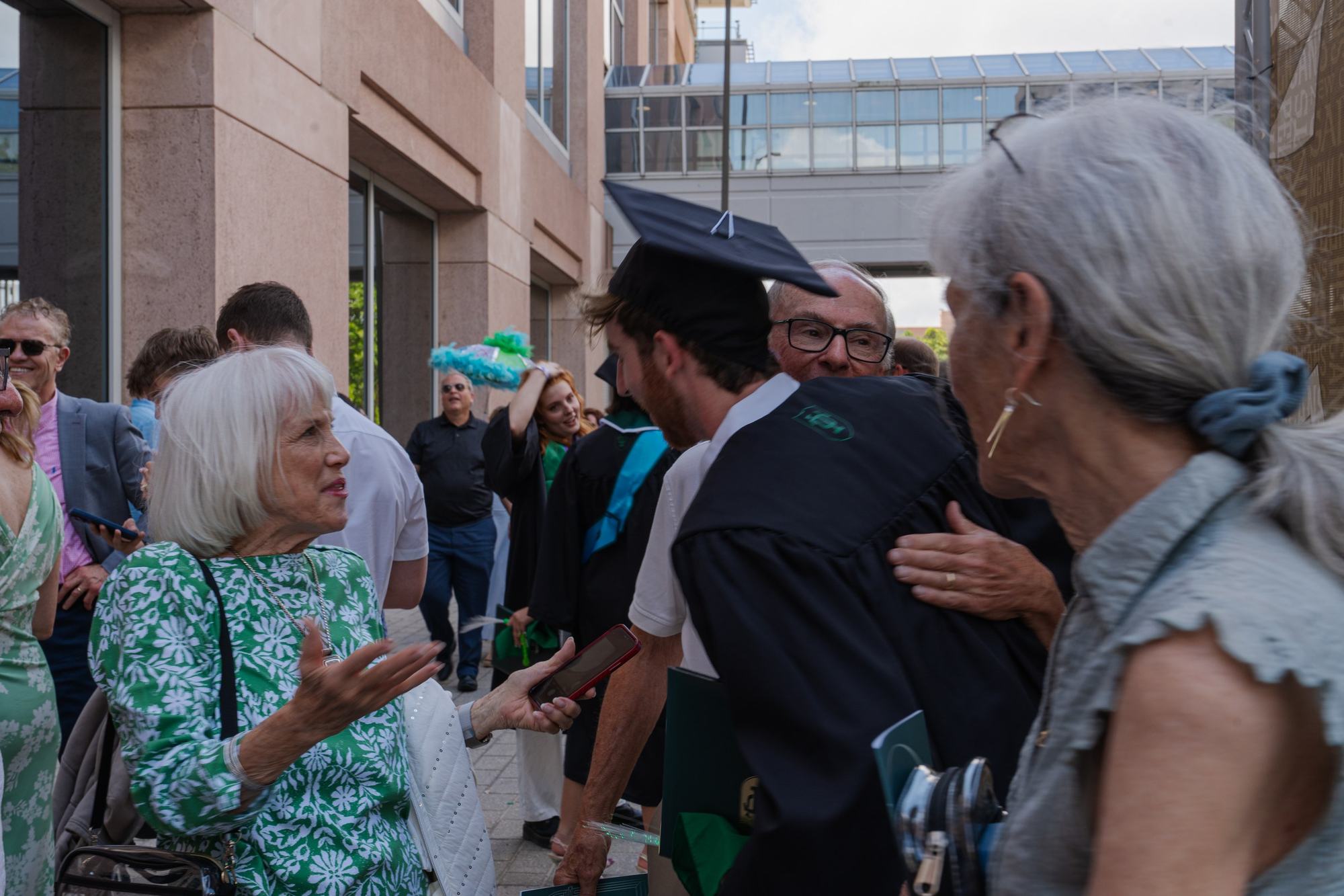 Graduate hugging family